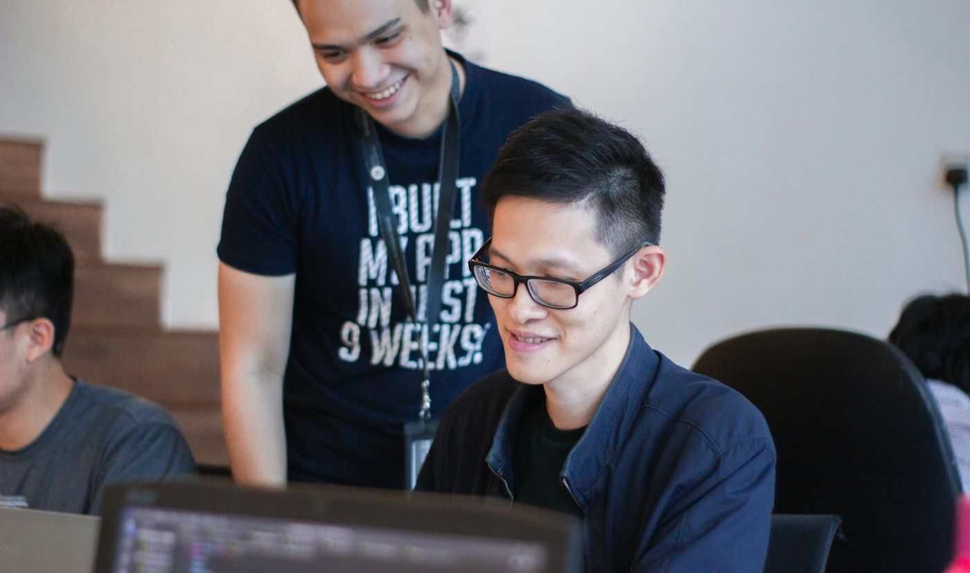 A mentor guiding a learner at a computer